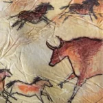A ancient painting showcasing horses and cattle galloping within a cave.