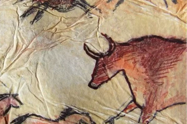 A ancient painting showcasing horses and cattle galloping within a cave.