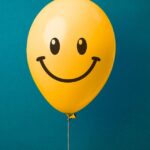 a smiling yellow balloon in a blue background