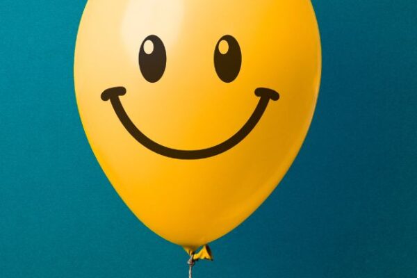 a smiling yellow balloon in a blue background
