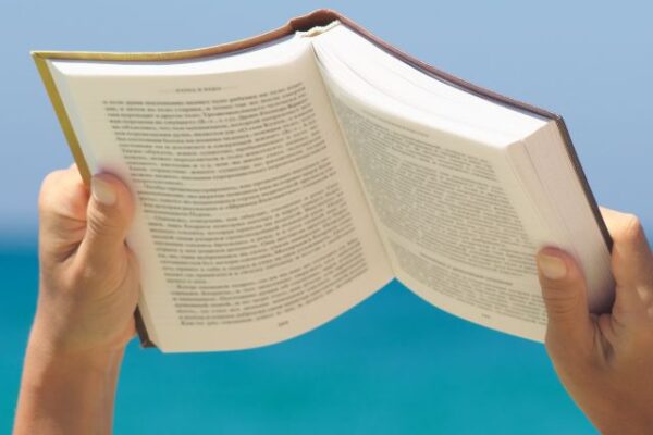 sitting and reading a book near the blue sea